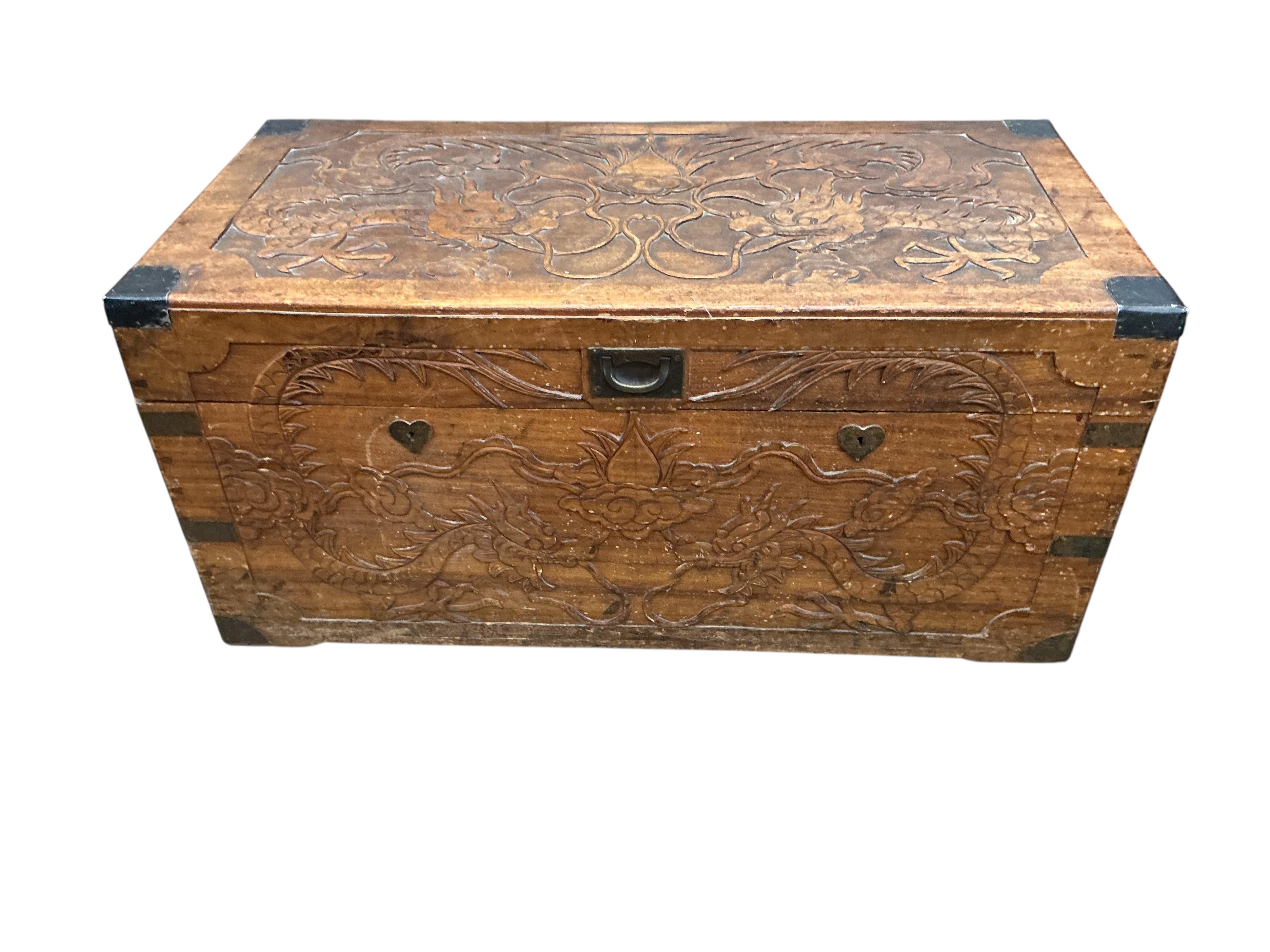 A Chinese carved hardwood ‘dragon’ trunk, width 98cm, depth 48cm, height 46cm